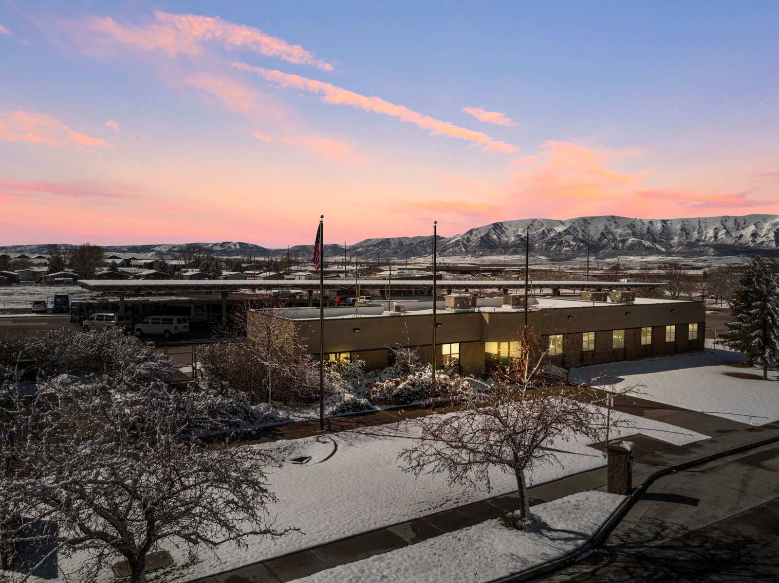 Aerial view at sunset in Logan, Utah, with snow-covered mountains behind
